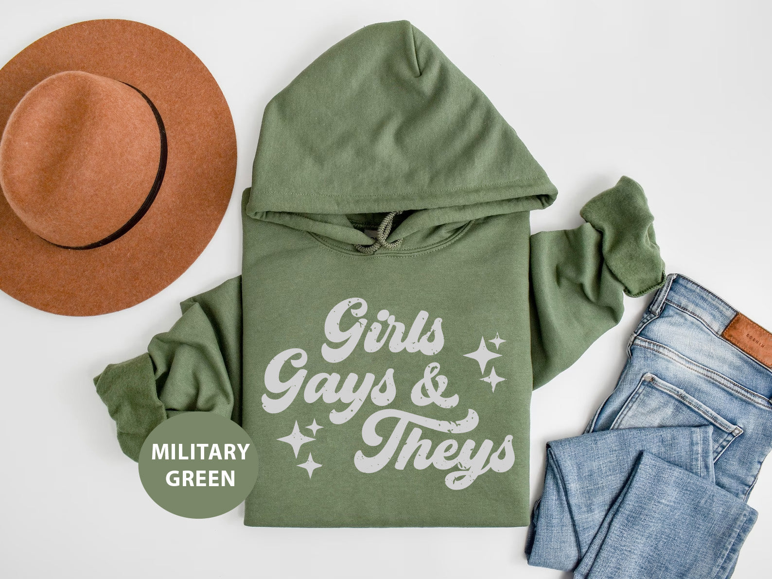 a green hoodie, jeans and a hat on a white surface