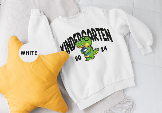 a white sweatshirt with a yellow star and a white sweatshirt with a dinosaur on it