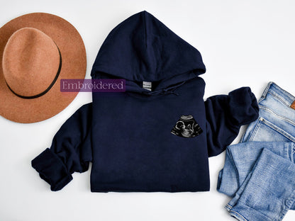 a hat, sweatshirt, jeans, and a pair of shoes on a white surface