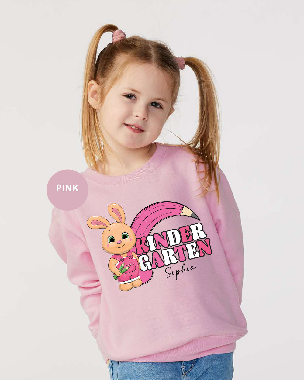 a little girl wearing a pink sweater with a bunny on it