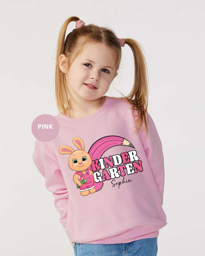 a little girl wearing a pink sweater with a bunny on it