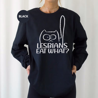 a woman wearing a black sweatshirt that says lesbians eat what?