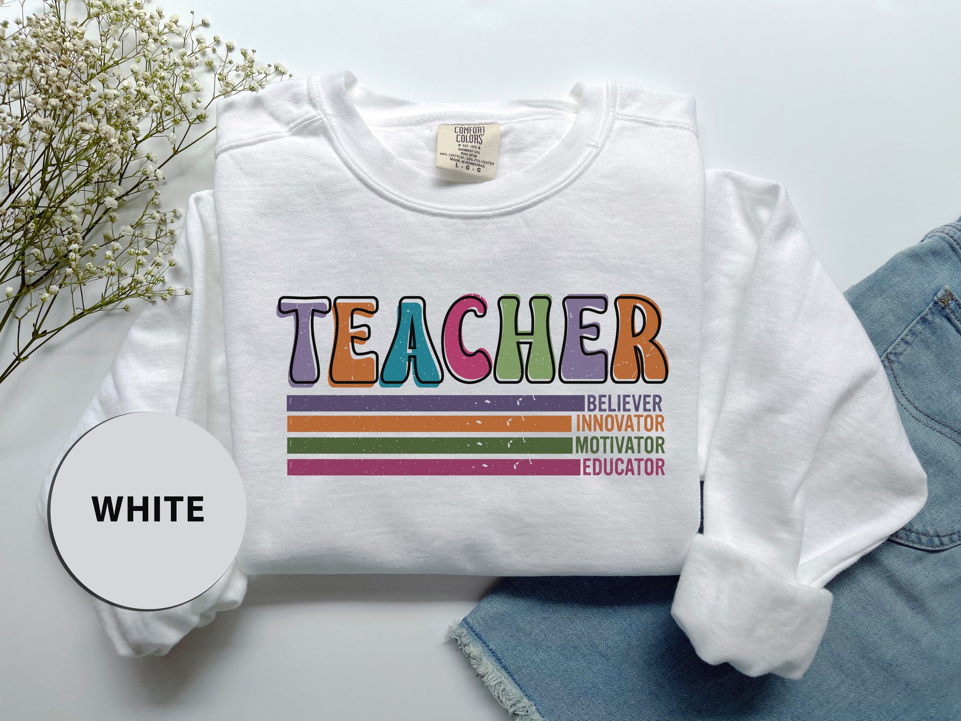 a t - shirt that says teacher with a rainbow on it