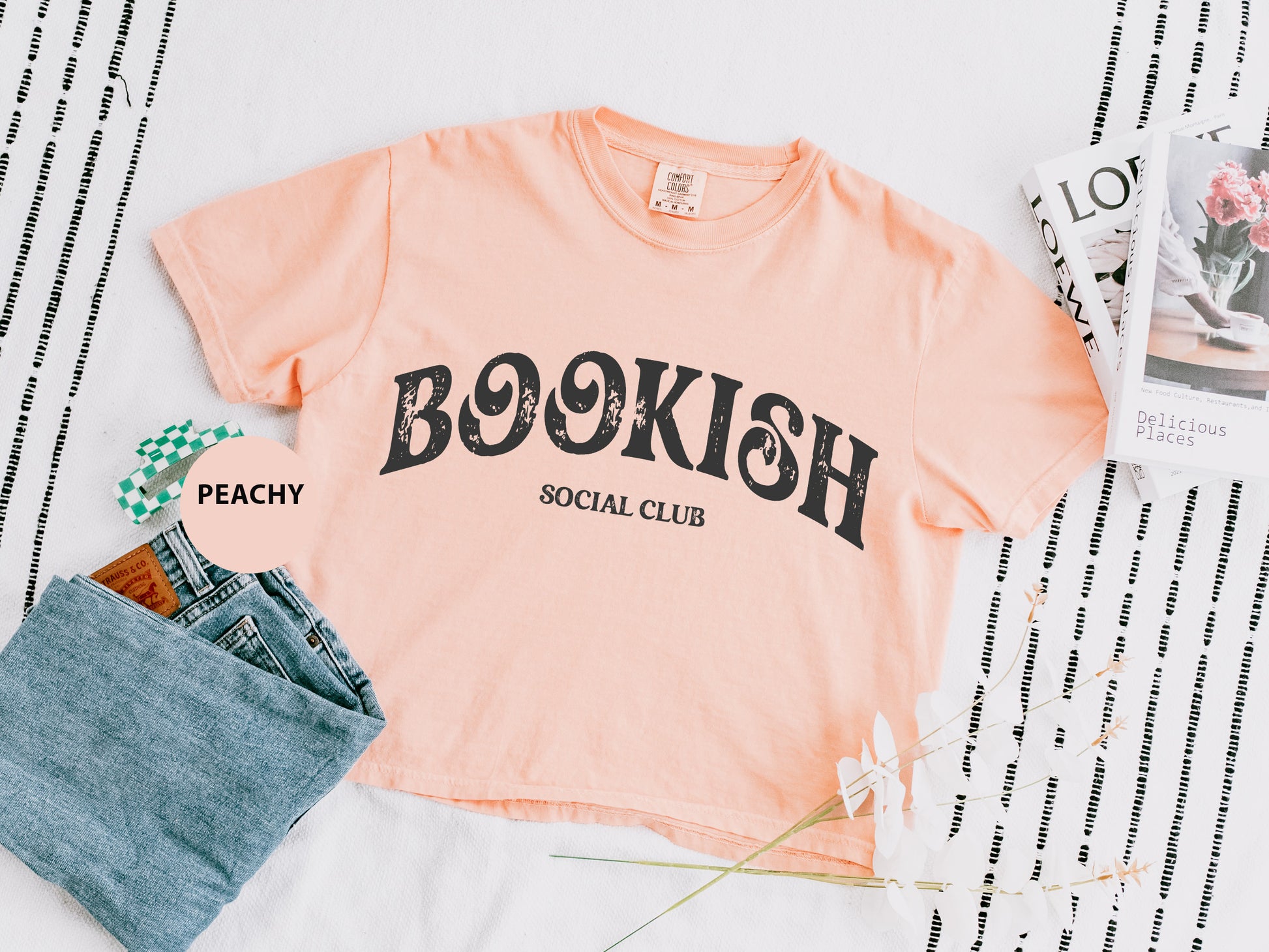 a t - shirt that says booksh social club next to a pair of jeans