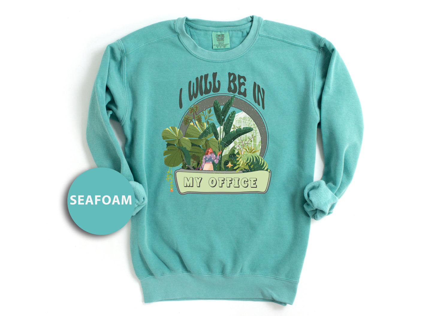 a green sweatshirt with a picture of a woman in a garden