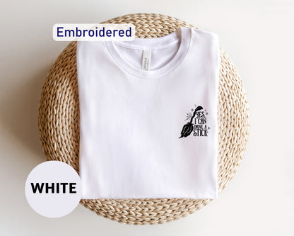 a white t - shirt with a black bird embroidered on it