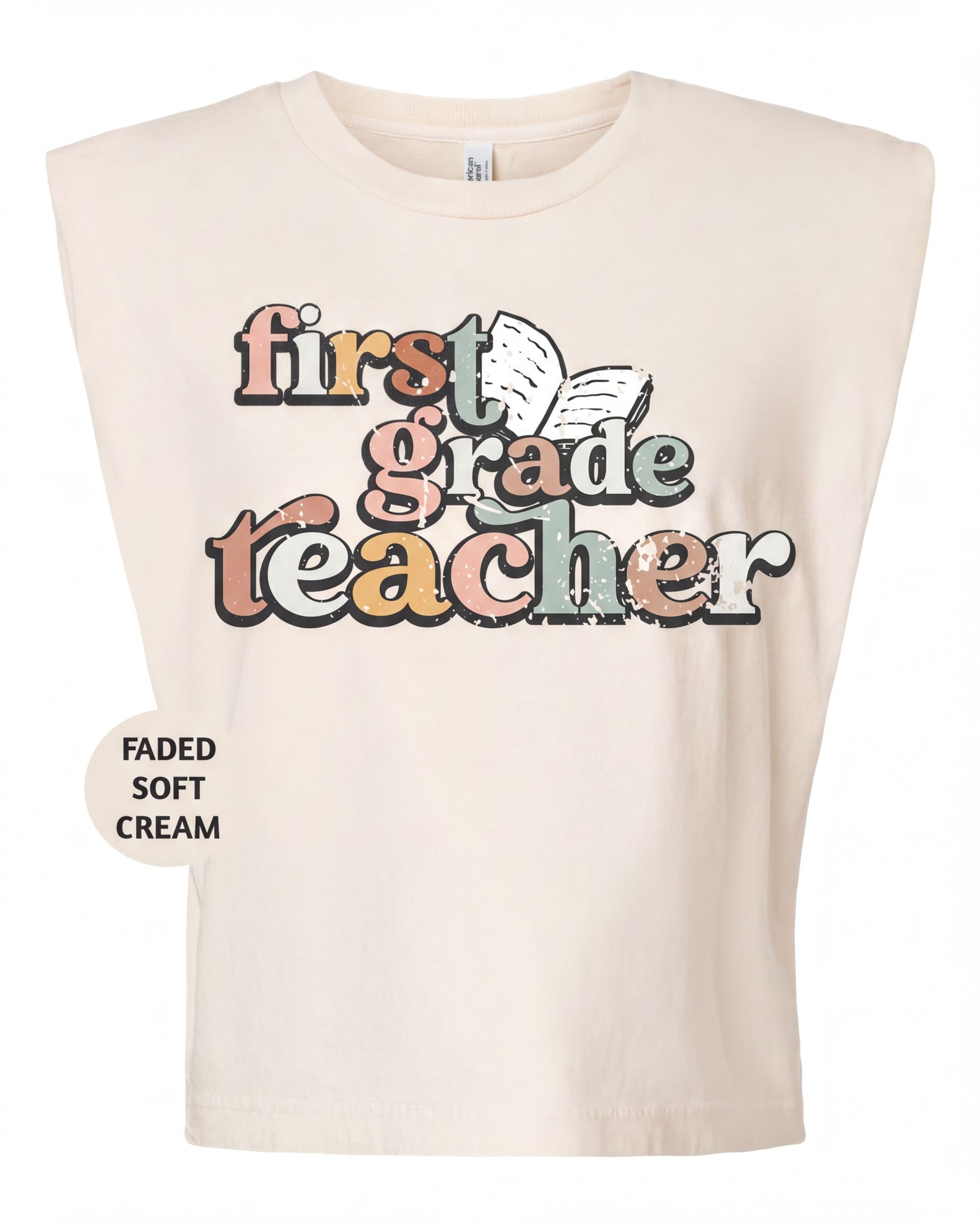 A beige t-shirt with a colorful graphic design that says "first grade teacher" in a playful font.