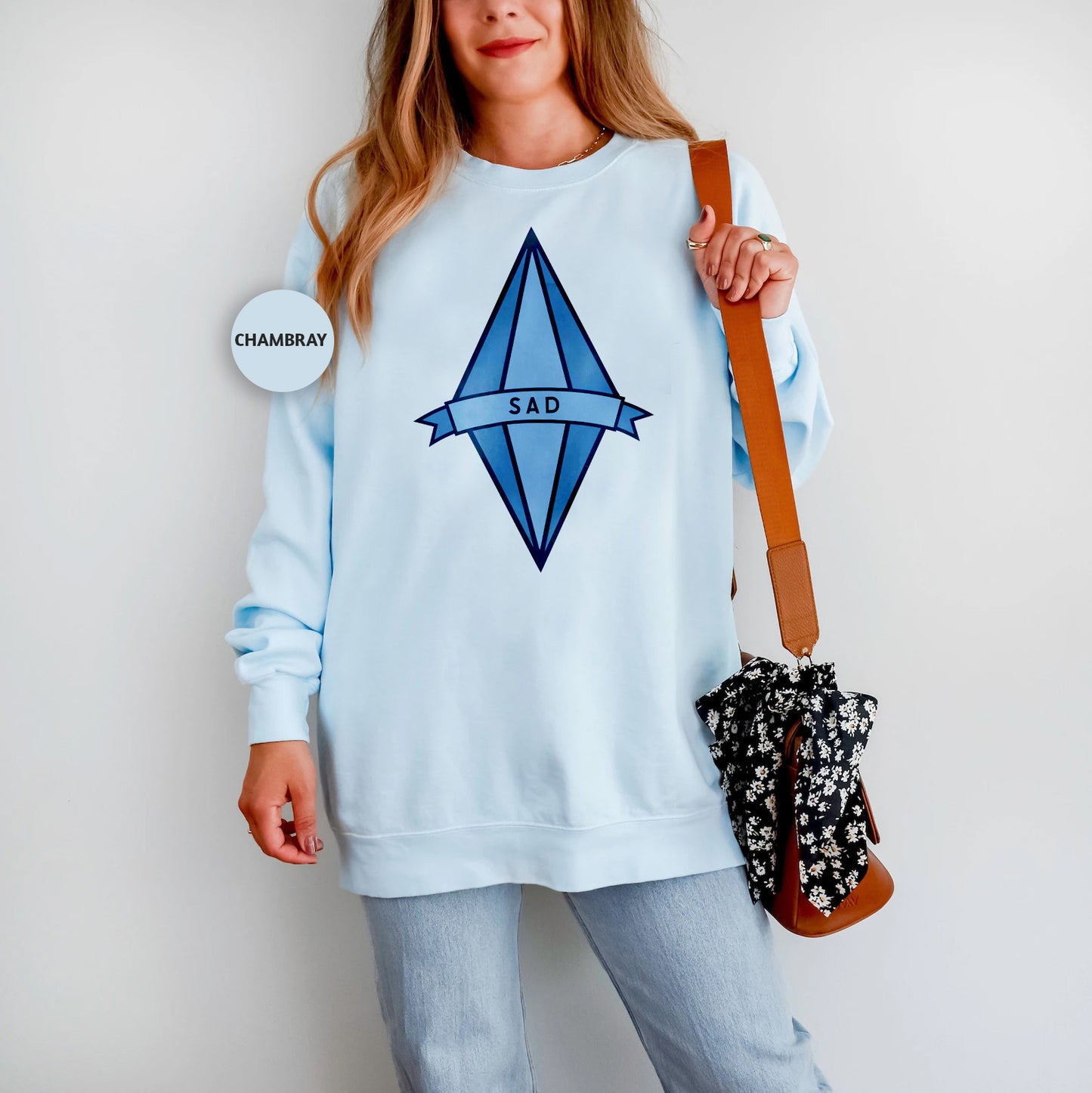 a woman in a blue sweatshirt holding a purse