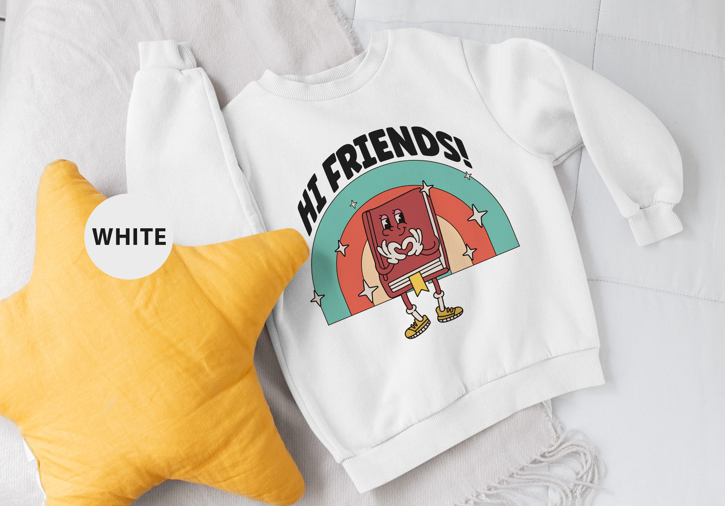 a white sweatshirt and a yellow star on a bed