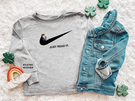 a t - shirt that says just read it next to a pair of jeans and