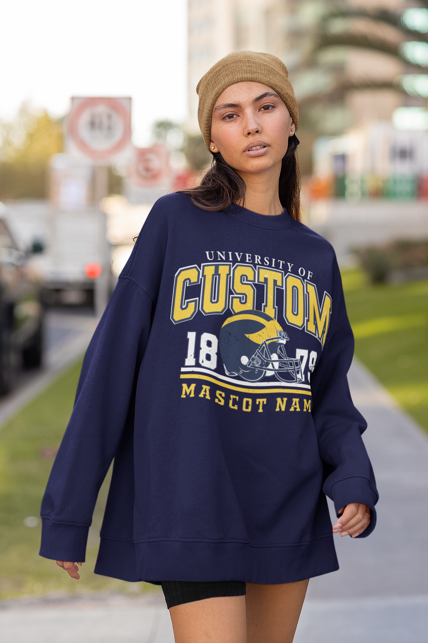 a woman walking down a sidewalk wearing a sweatshirt