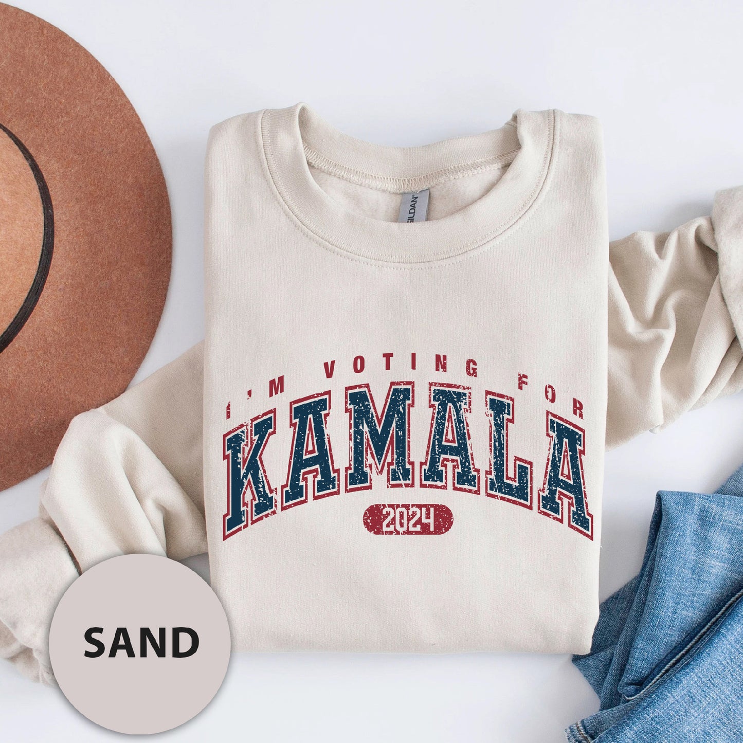 a hat, sweatshirt, and jeans are laid out on a white surface