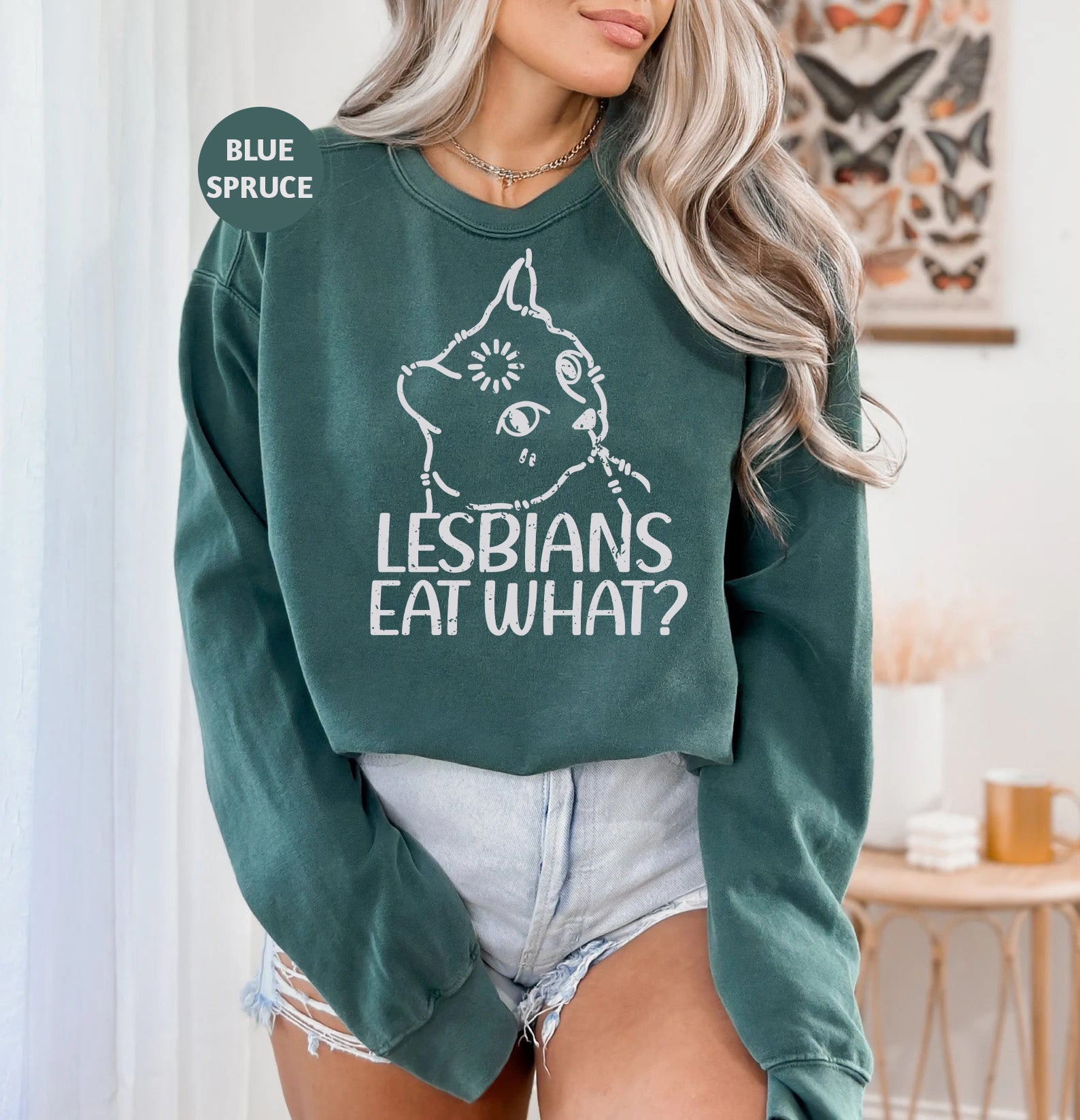 a woman wearing a green sweatshirt that says lesbians eat what?