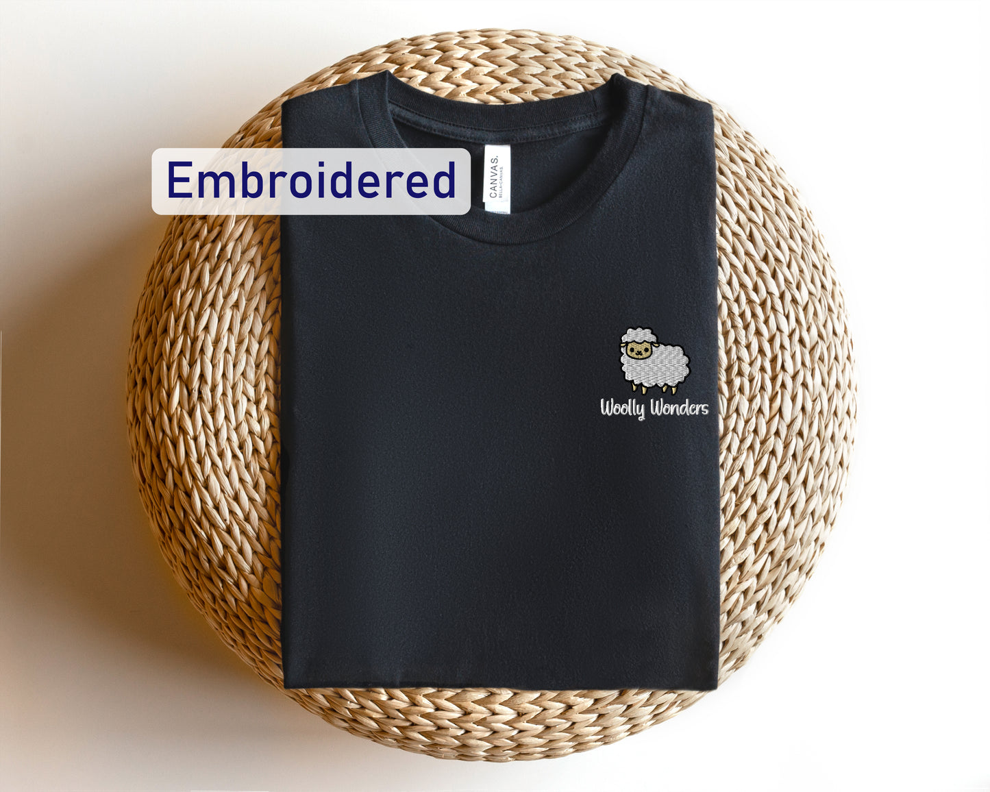 a black t - shirt with an embroidered sheep on it