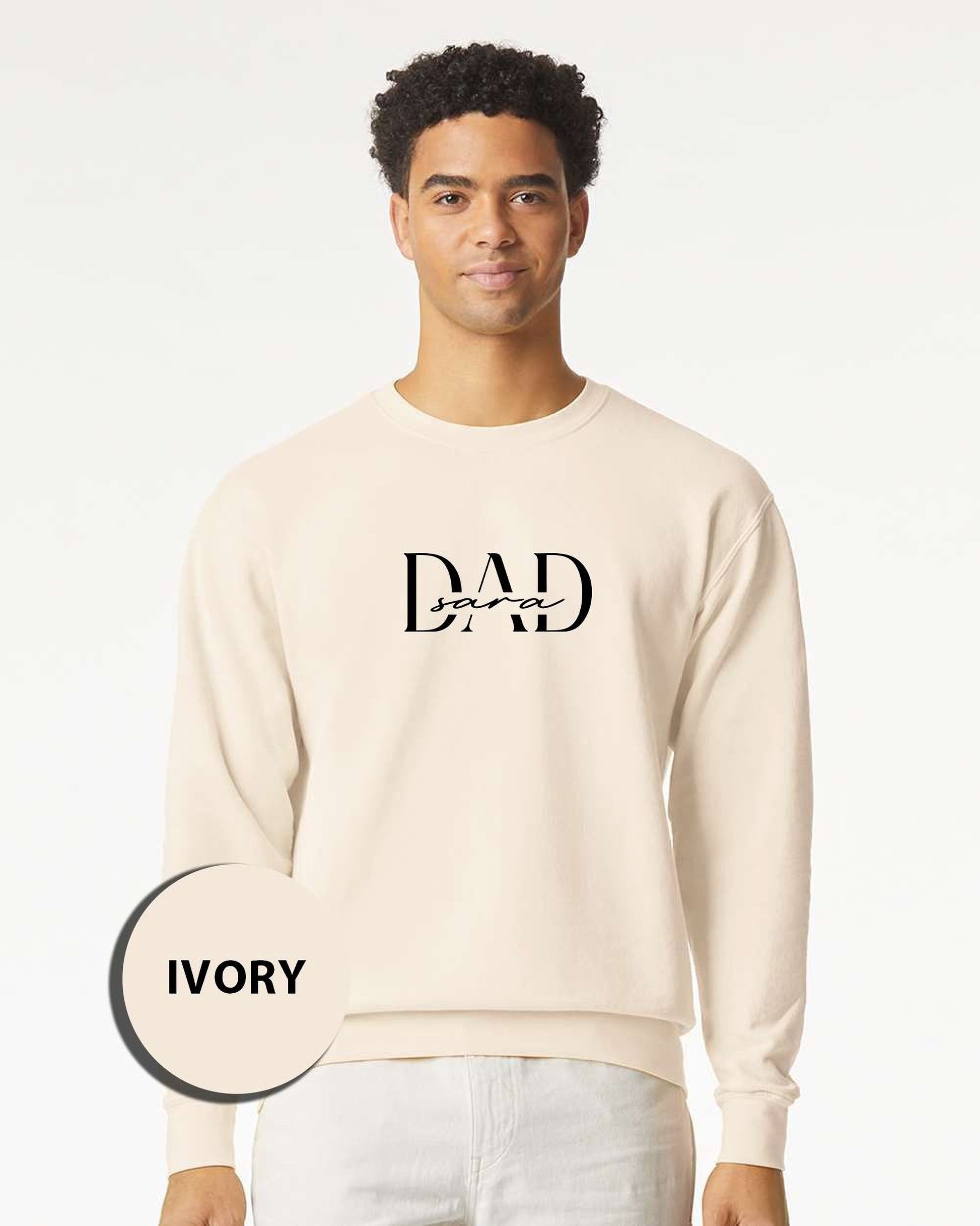 A man wearing a cream-colored sweater with the text "DAD" printed on it.