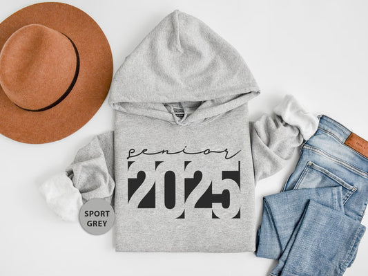 a hat, sweatshirt, jeans, and a pair of shoes on a white surface