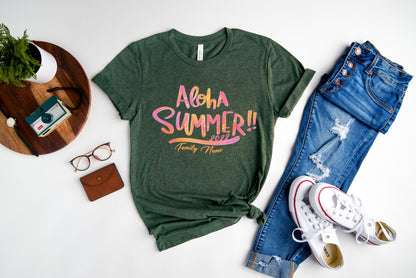 A green t-shirt with a colorful graphic design, a pair of blue jeans, a pair of white sneakers, a pair of glasses, a wallet, and a small plant on a white background.