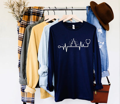 A clothing rack displaying various items, including a blue long-sleeve shirt with a white line design, a plaid shirt, a yellow shirt, and a pair of blue jeans.