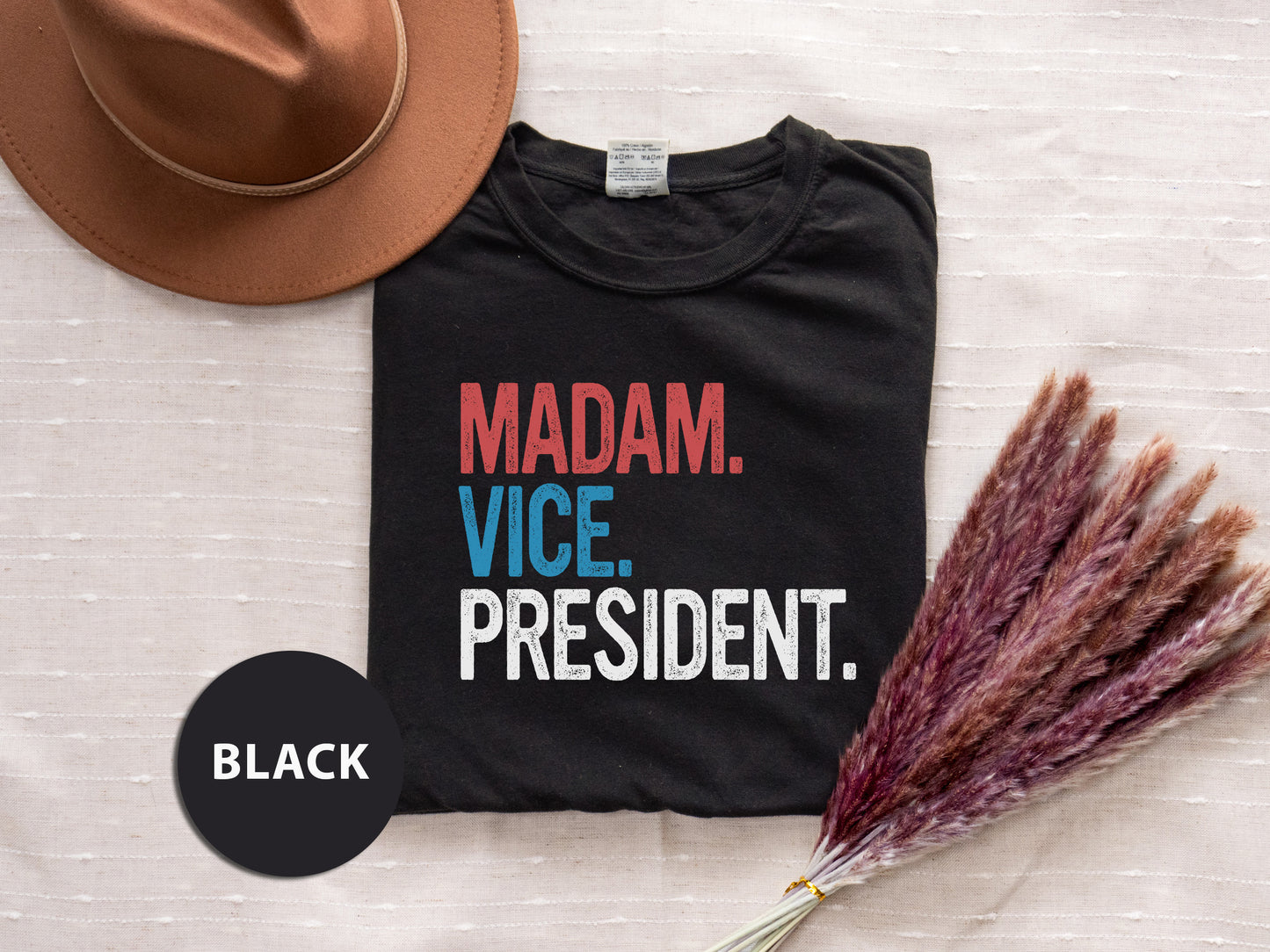 a t - shirt that says madam vice president next to a hat