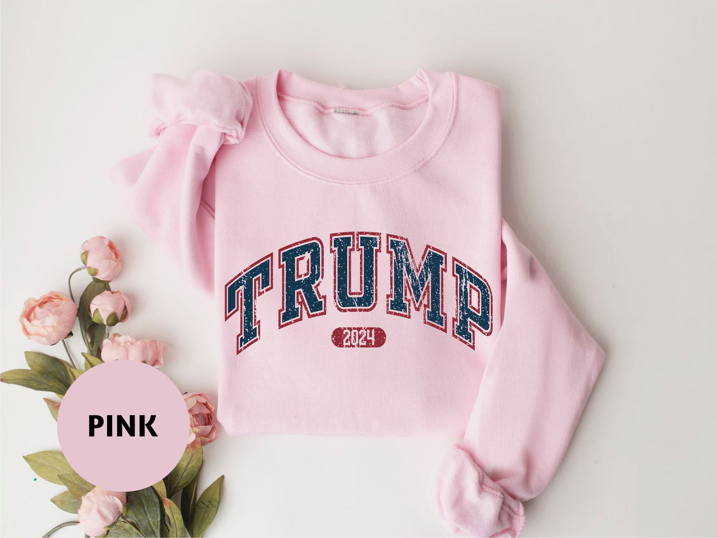 a pink sweater with the word trump printed on it