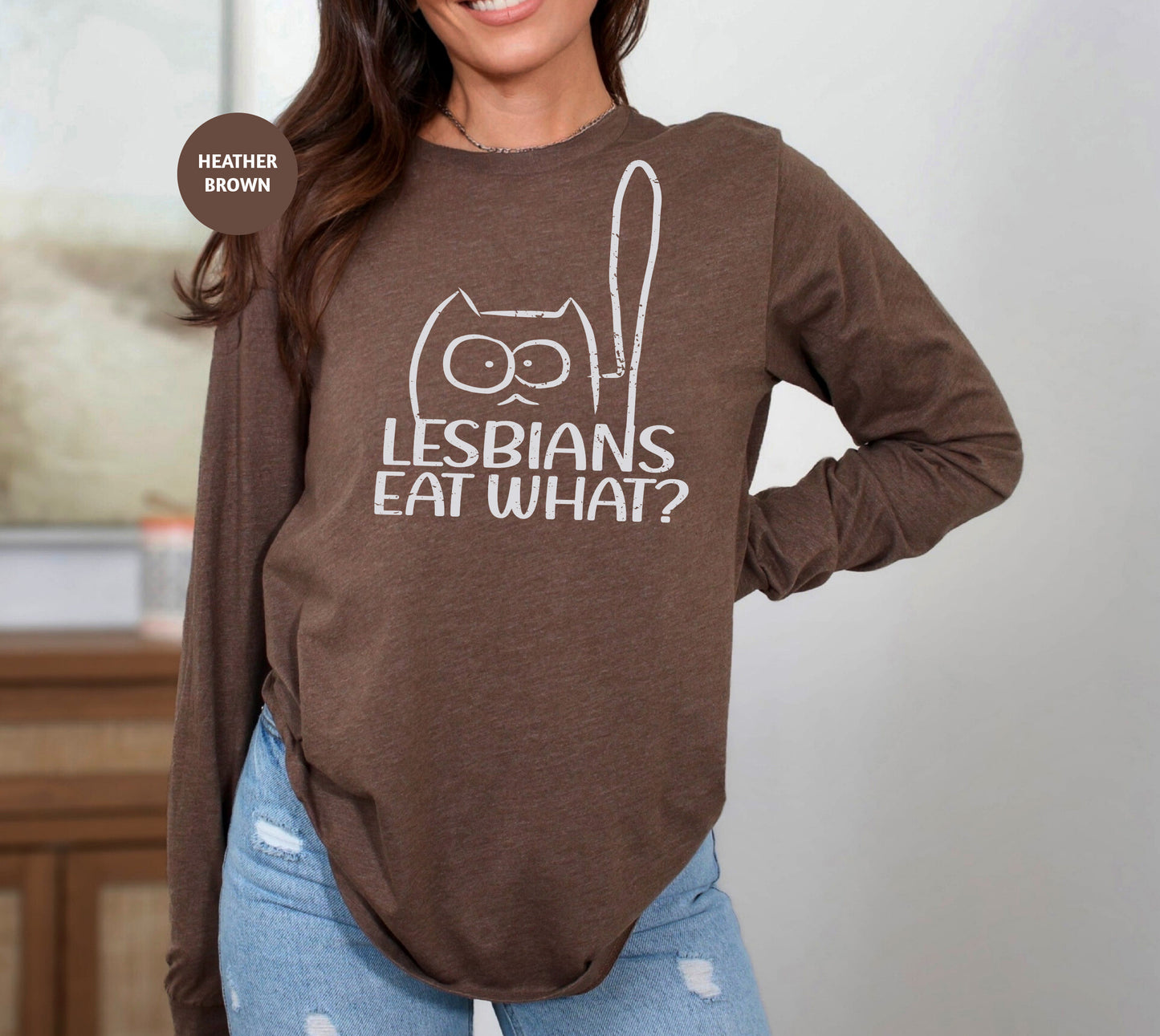 a woman wearing a brown shirt with the words lesbians eat what? on it