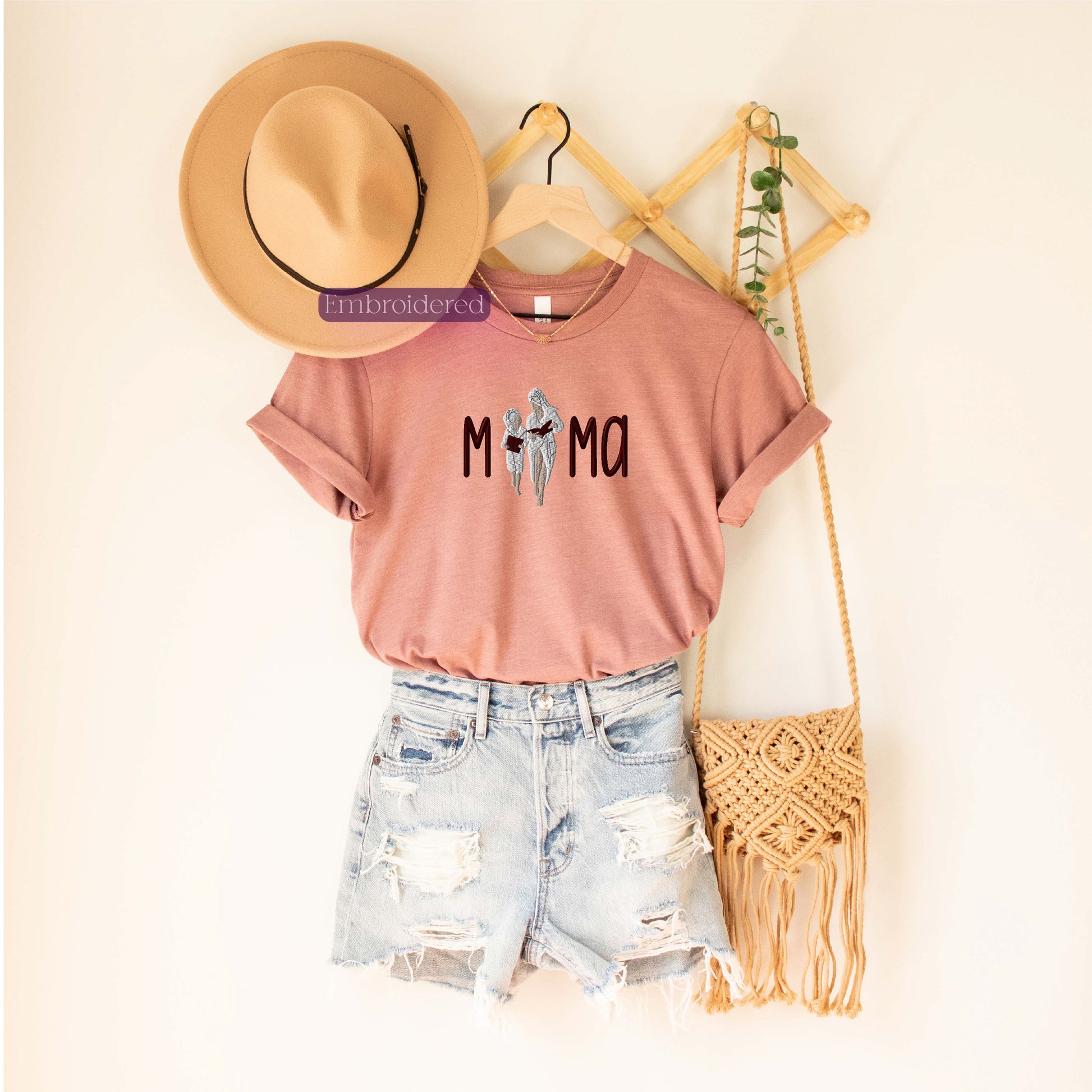 a t - shirt that says mama with a cowboy hat on top of it