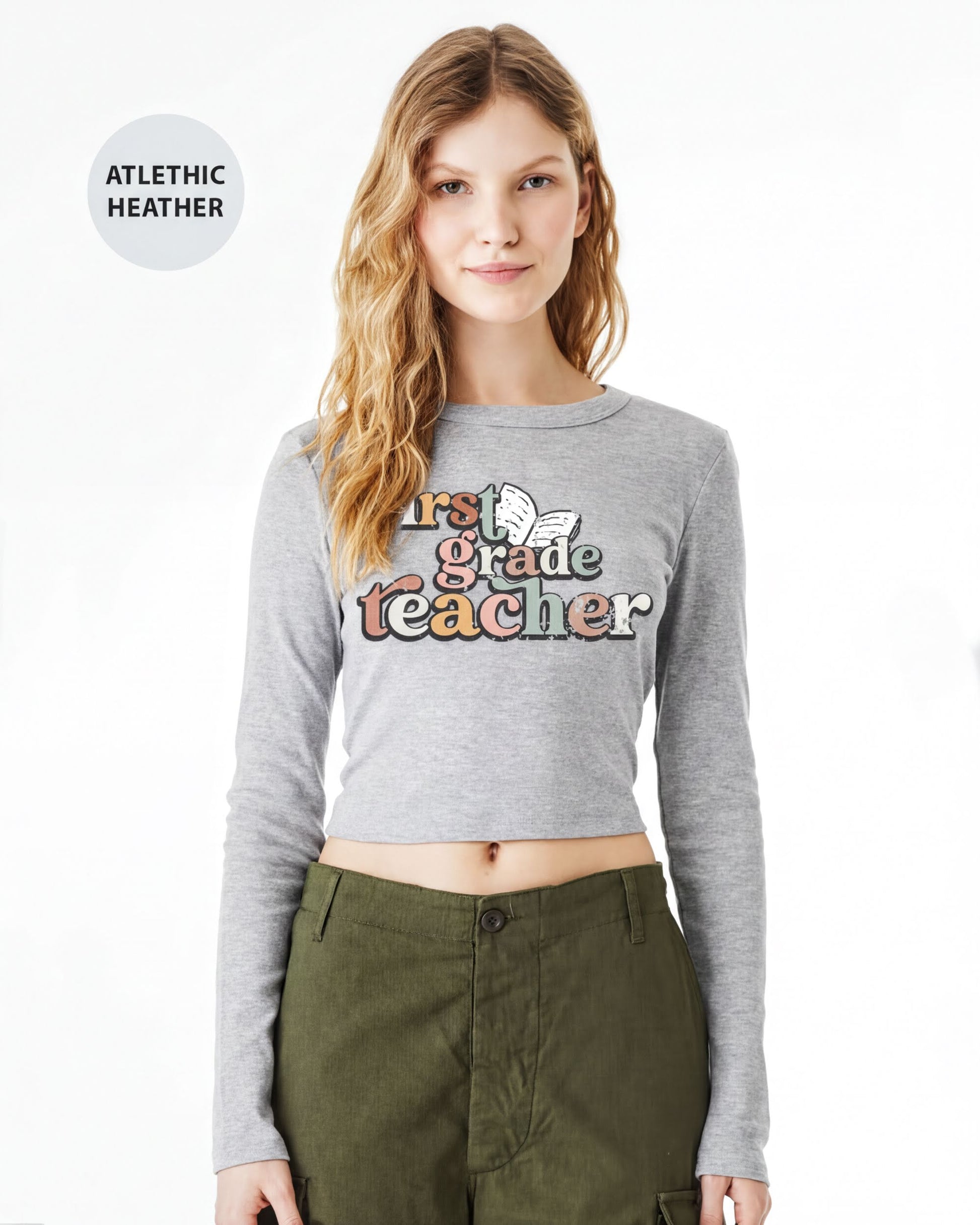 A young woman with long, wavy blonde hair wearing a gray long-sleeved shirt with a graphic design and green cargo pants.