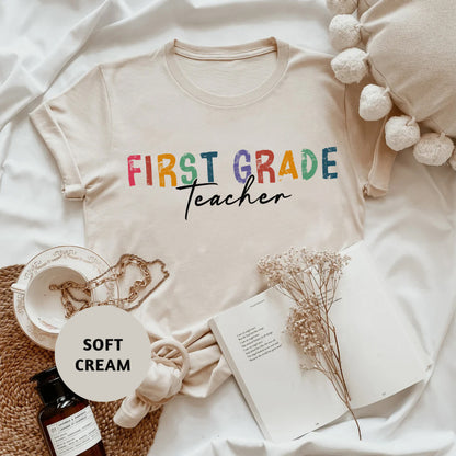 a t - shirt that says first grade teacher next to other items