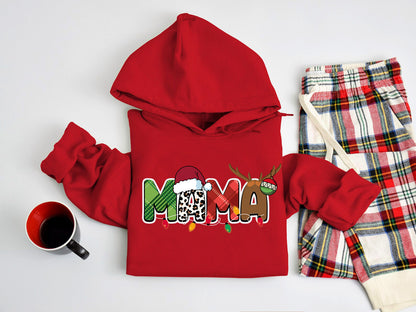 A red hoodie with the word "MAMA" printed on it, along with a pair of plaid pajama pants and a mug, all laid out on a white surface.