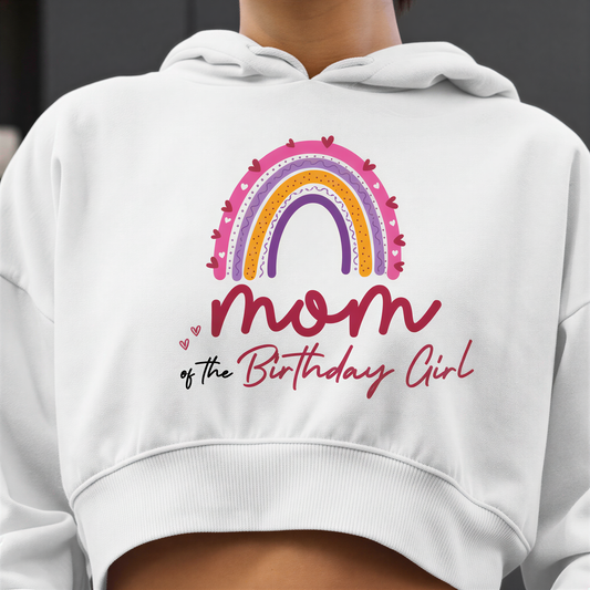 A white hoodie with a colorful graphic of a rainbow and the text "Mom of the Birthday Girl" printed on it.