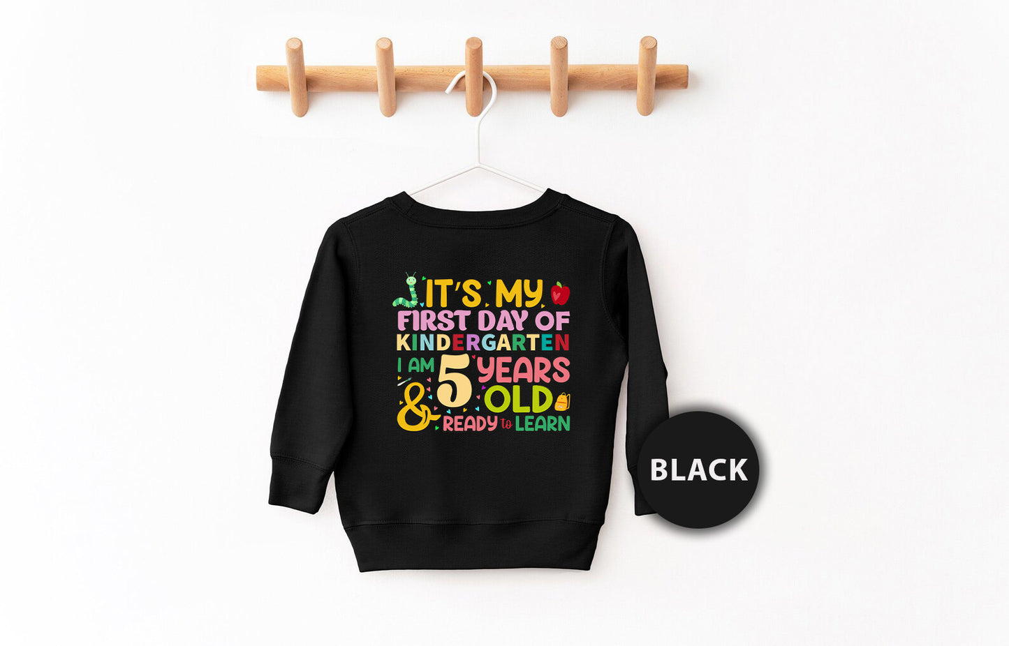 a black sweatshirt hanging on a clothes rack