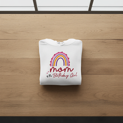 A white hoodie with a colorful graphic and text printed on it, laid out on a wooden surface.