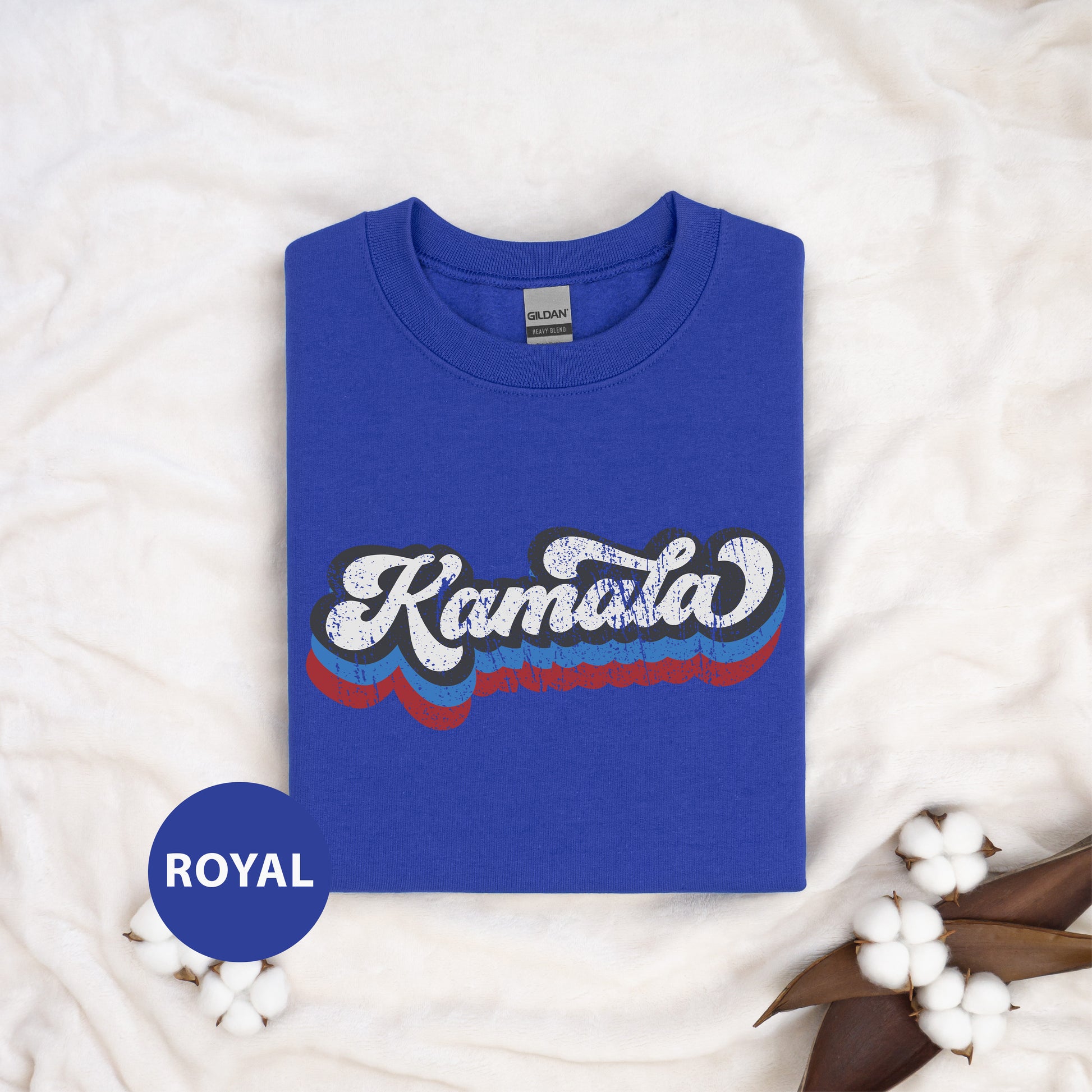 a blue kansas t - shirt sitting on top of a white blanket