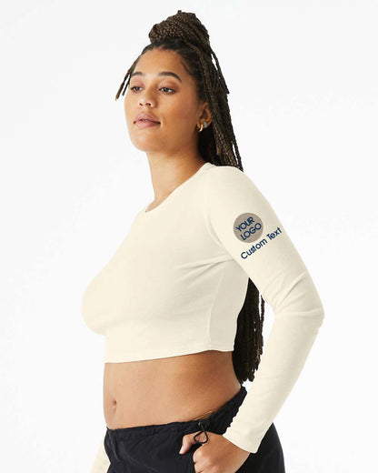 a woman wearing a white crop top and black pants