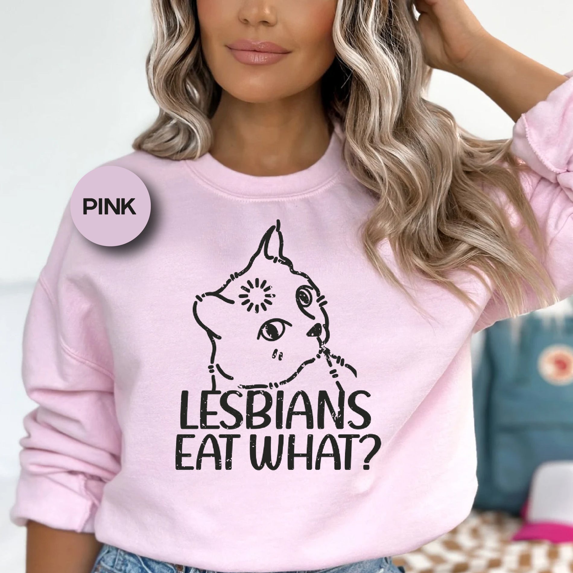 a woman wearing a pink sweatshirt that says lesbians eat what?