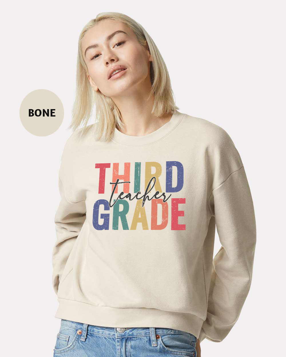 a woman wearing a sweatshirt that says third grade