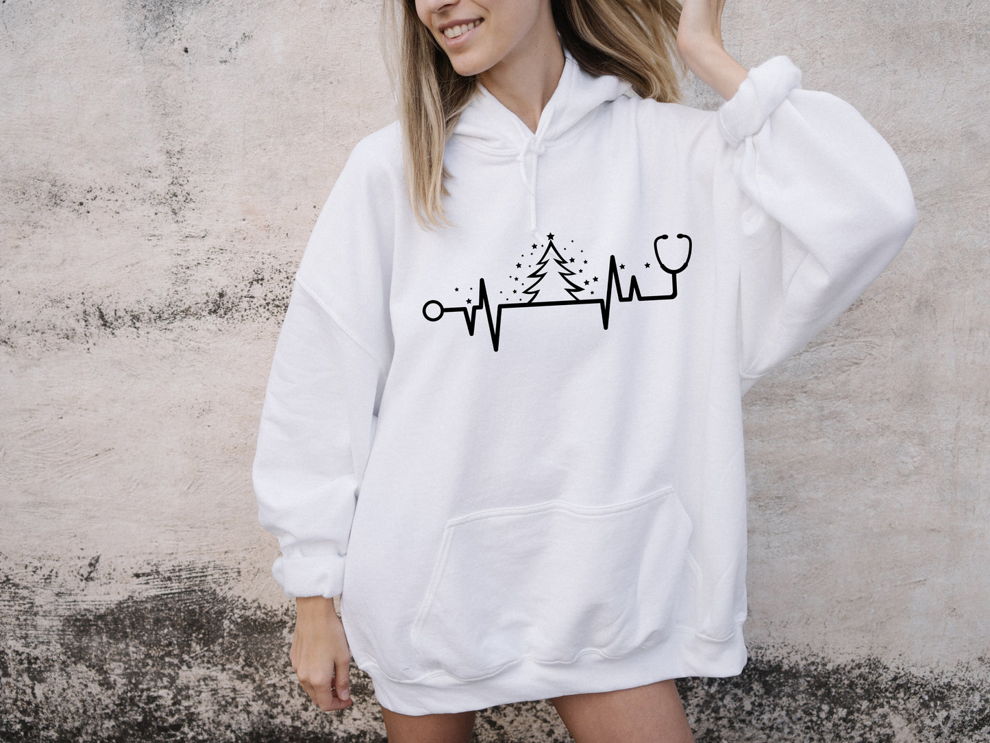 A woman wearing a white hoodie with a graphic design on it.