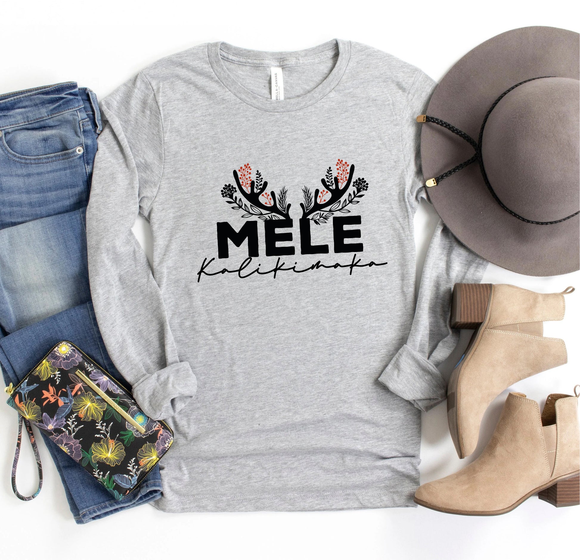 A casual outfit consisting of a gray long-sleeved shirt with a floral design, a pair of jeans, a hat, and beige ankle boots, along with a purse and a wallet.