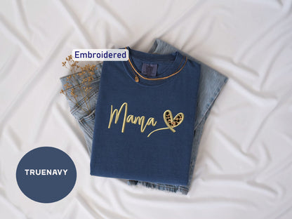 a t - shirt that says mama on it next to a pair of jeans