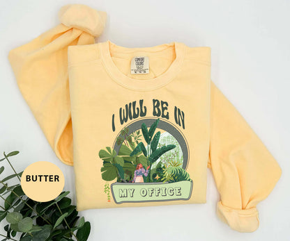 a yellow sweatshirt with a picture of a woman in a garden on it