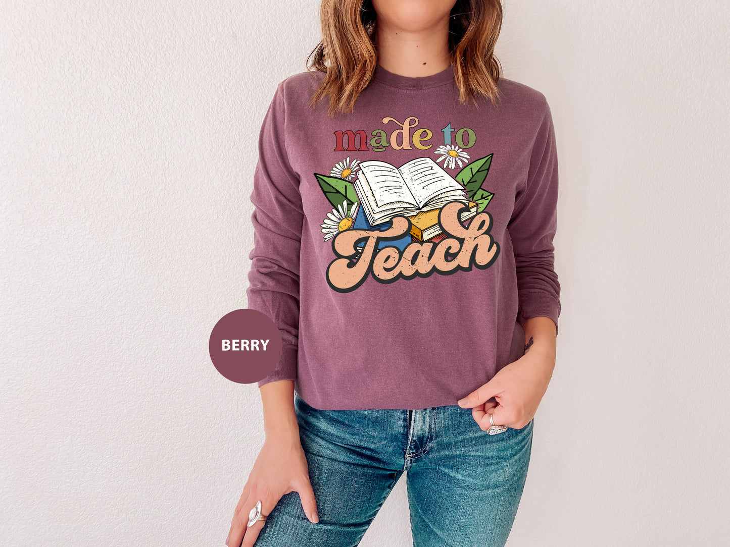 a woman wearing a sweatshirt that reads made to teach