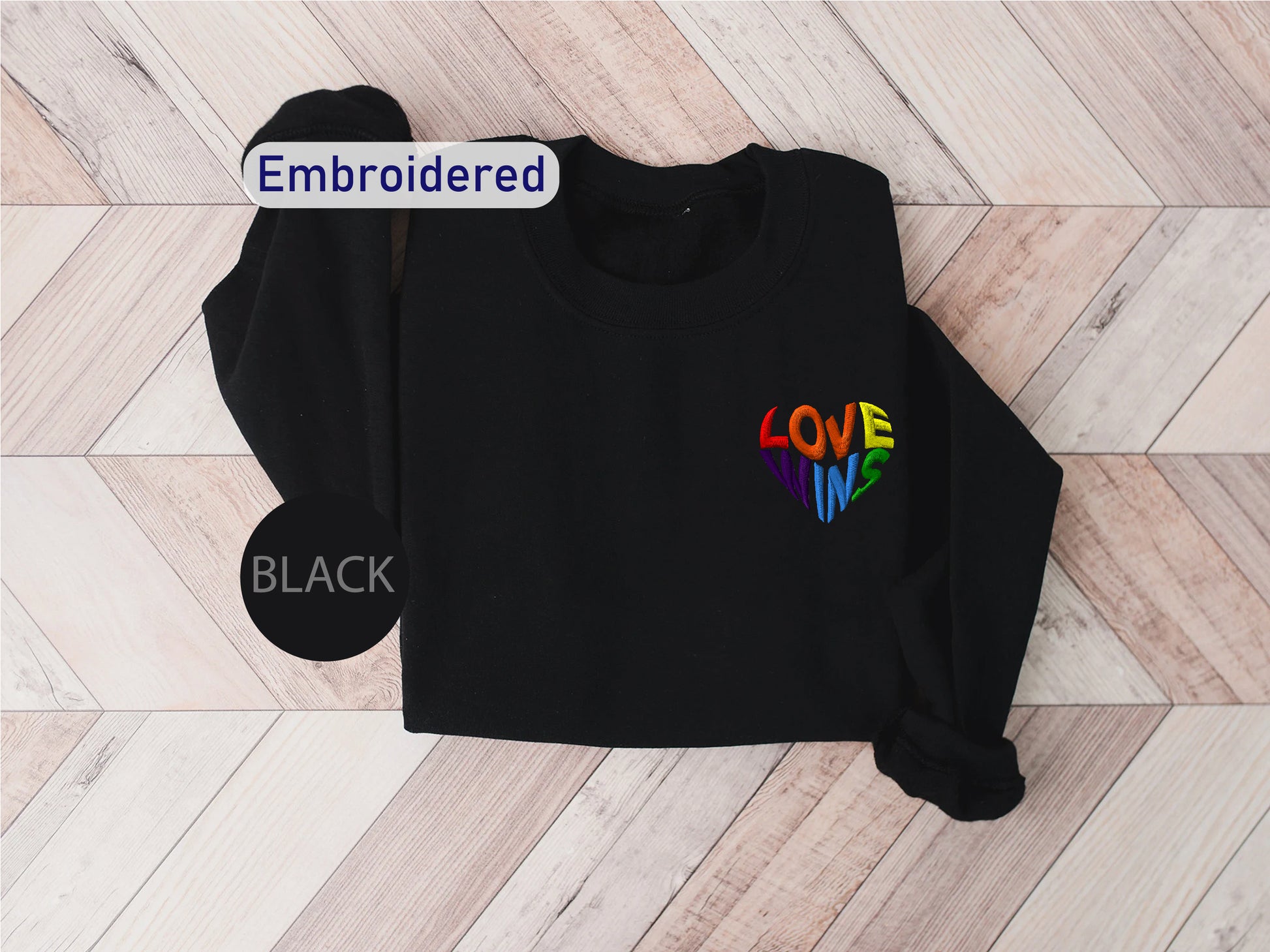 a black shirt with the word love in a rainbow heart