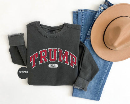 a hat, jeans, and a sweatshirt with the word trump on it