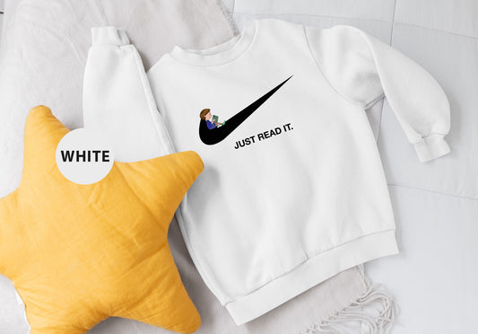 a white sweatshirt and a yellow star on a bed