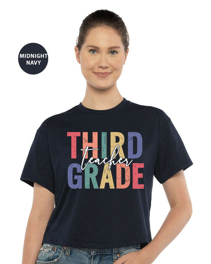 a woman wearing a black shirt that says third grade