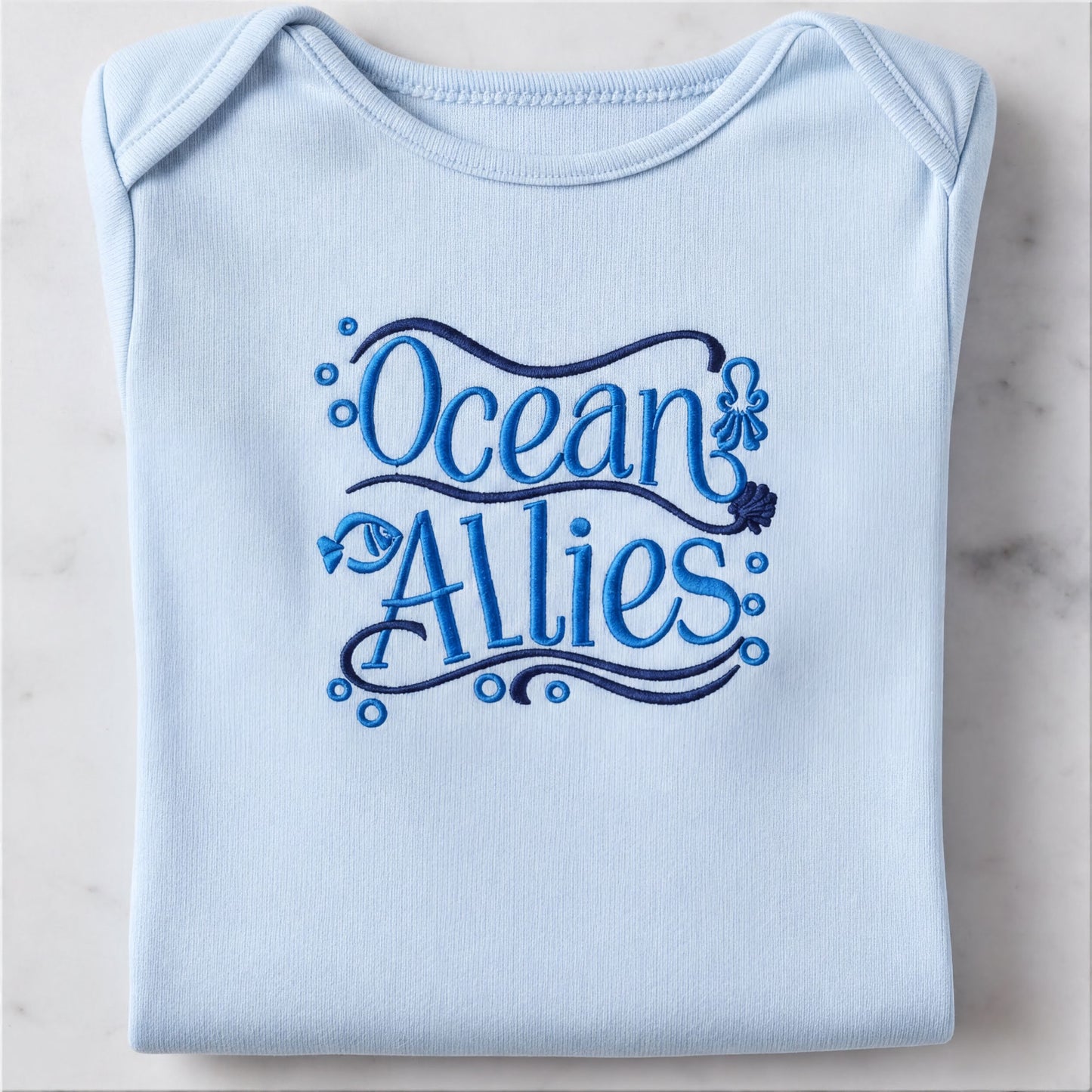 A light blue baby onesie with the text "Ocean Allies" embroidered on it.