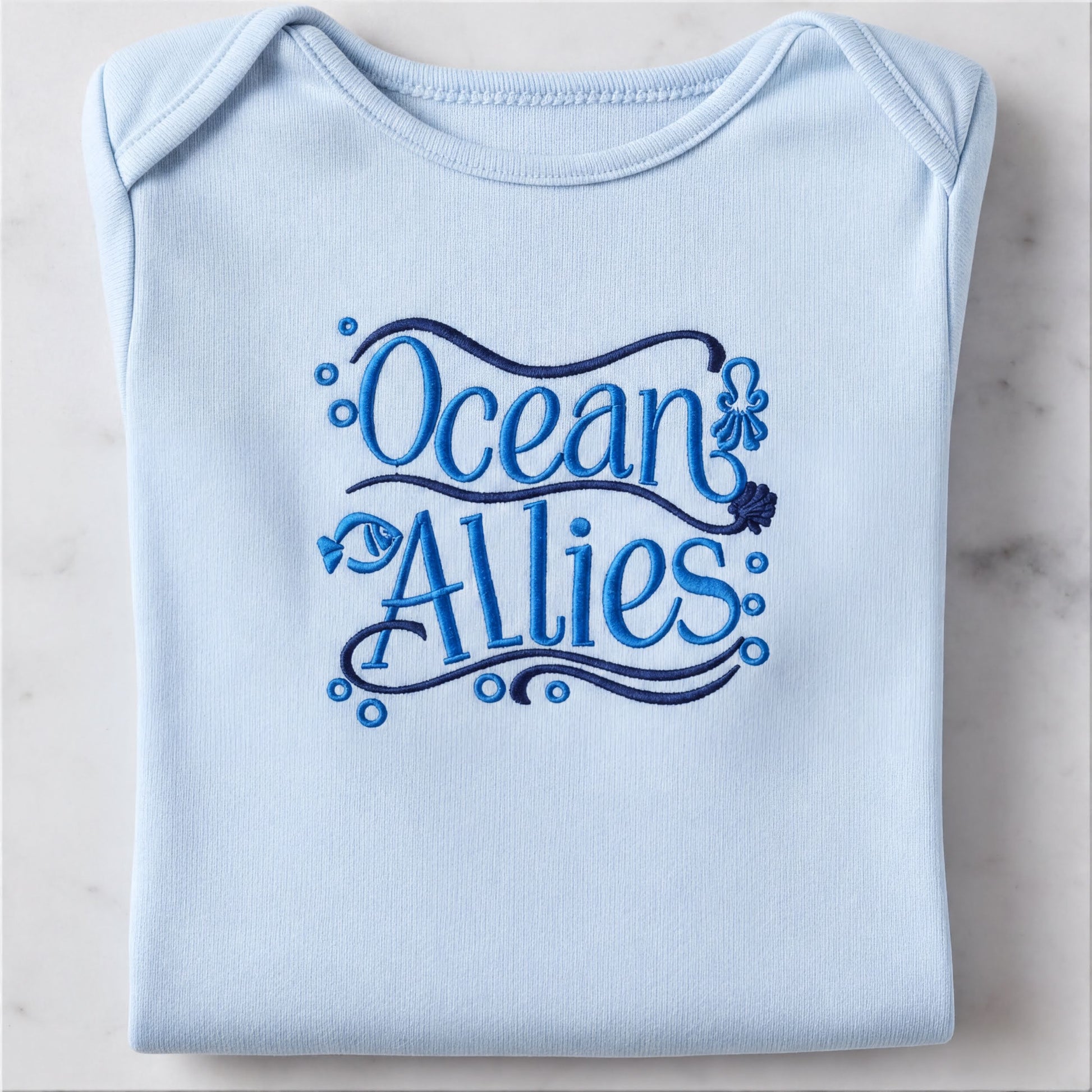 A light blue baby onesie with the text "Ocean Allies" embroidered on it.