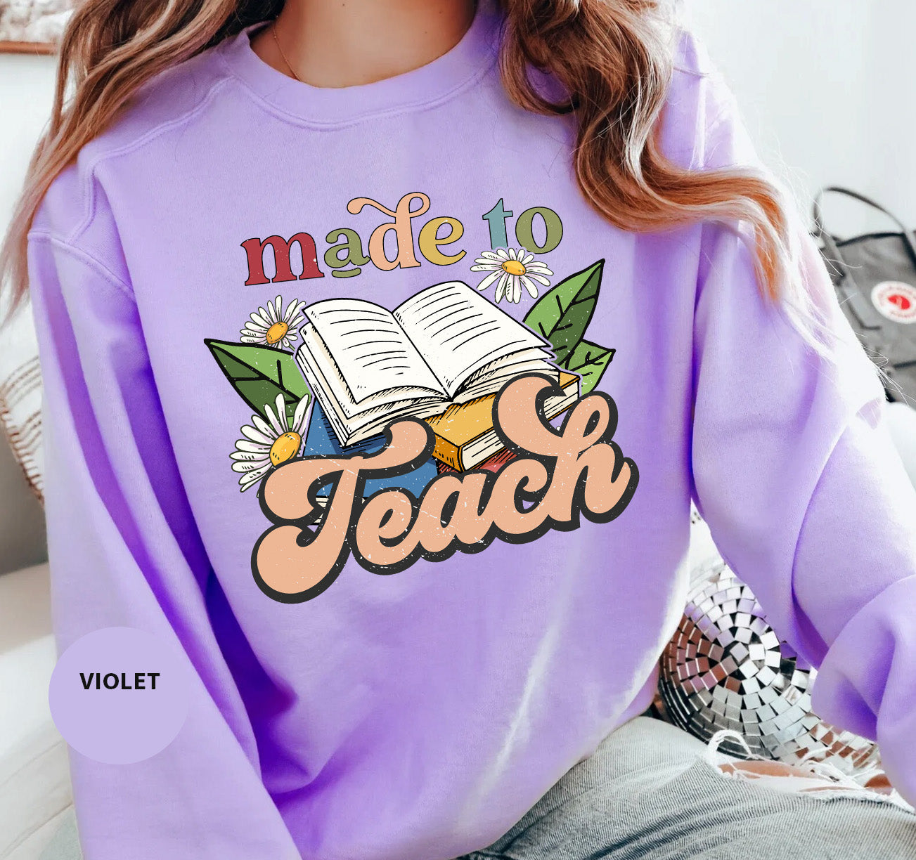 a woman wearing a purple sweatshirt that says made to teach