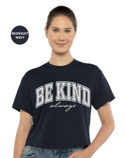 a woman wearing a black shirt with the words be kind on it