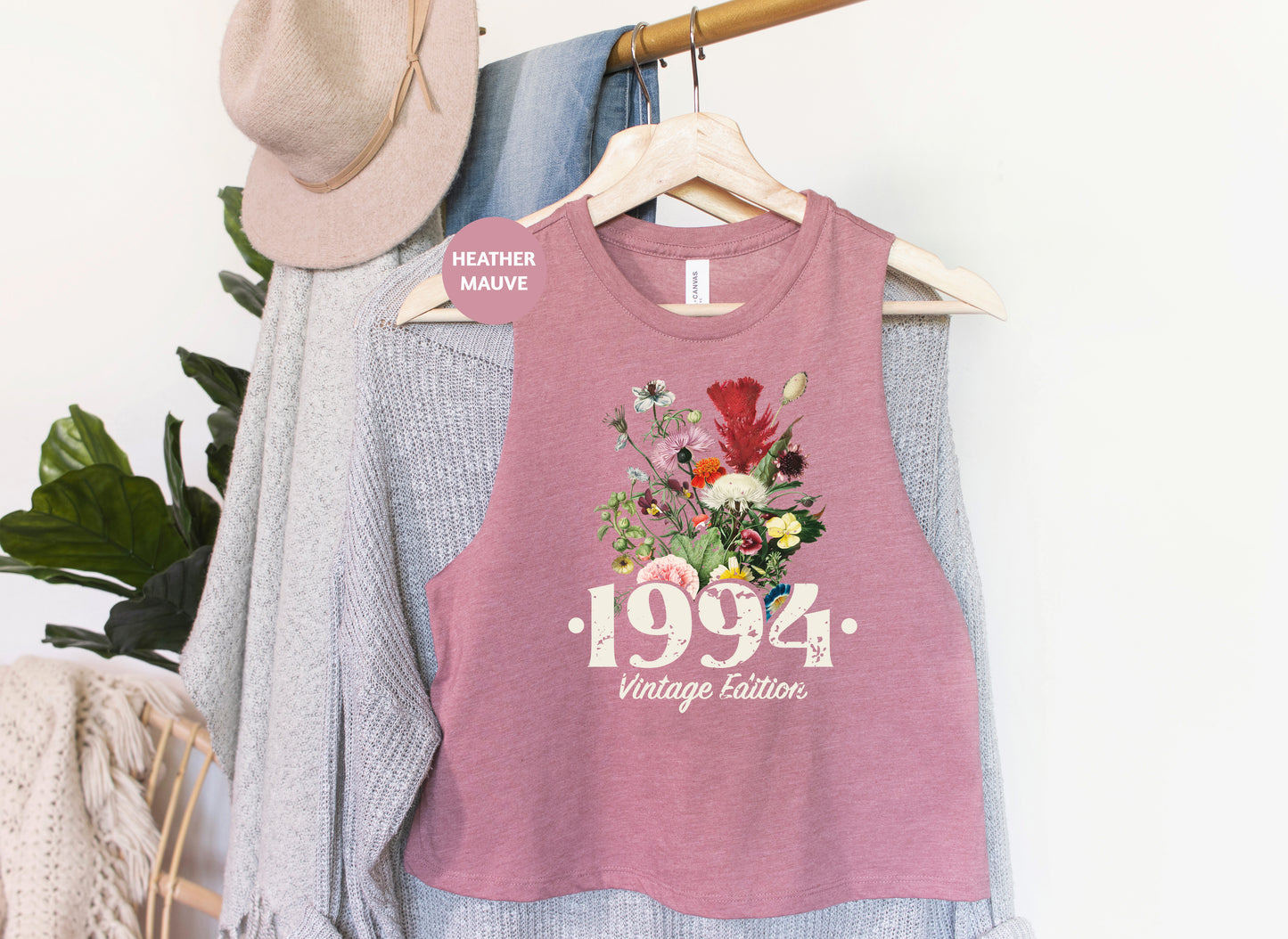 a pink shirt with flowers on it hanging on a rack